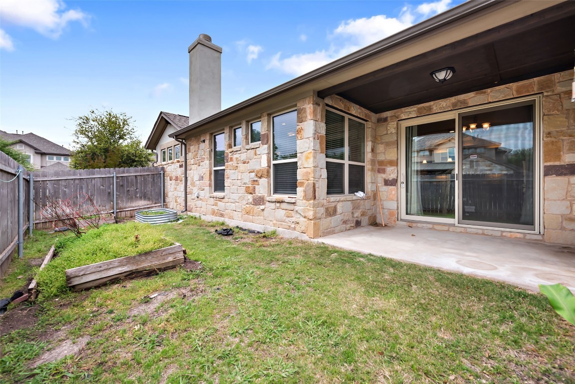 2000 Manada Trail Leander, TX 78641 - Photo 33 of 36 A stone-clad exterior with multiple windows and a covered patio offers seamless indoor-outdoor living.