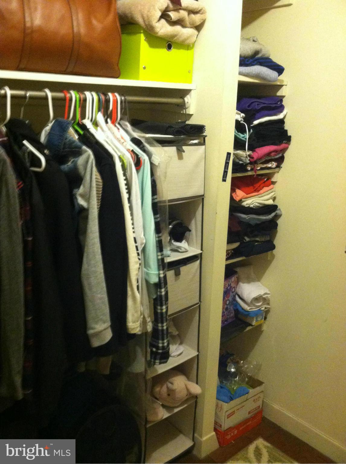 2201 L Street Northwest, Unit 820 Washington, DC 20037 - Photo 3 of 12 a view of walk in closet with clothes and shoes