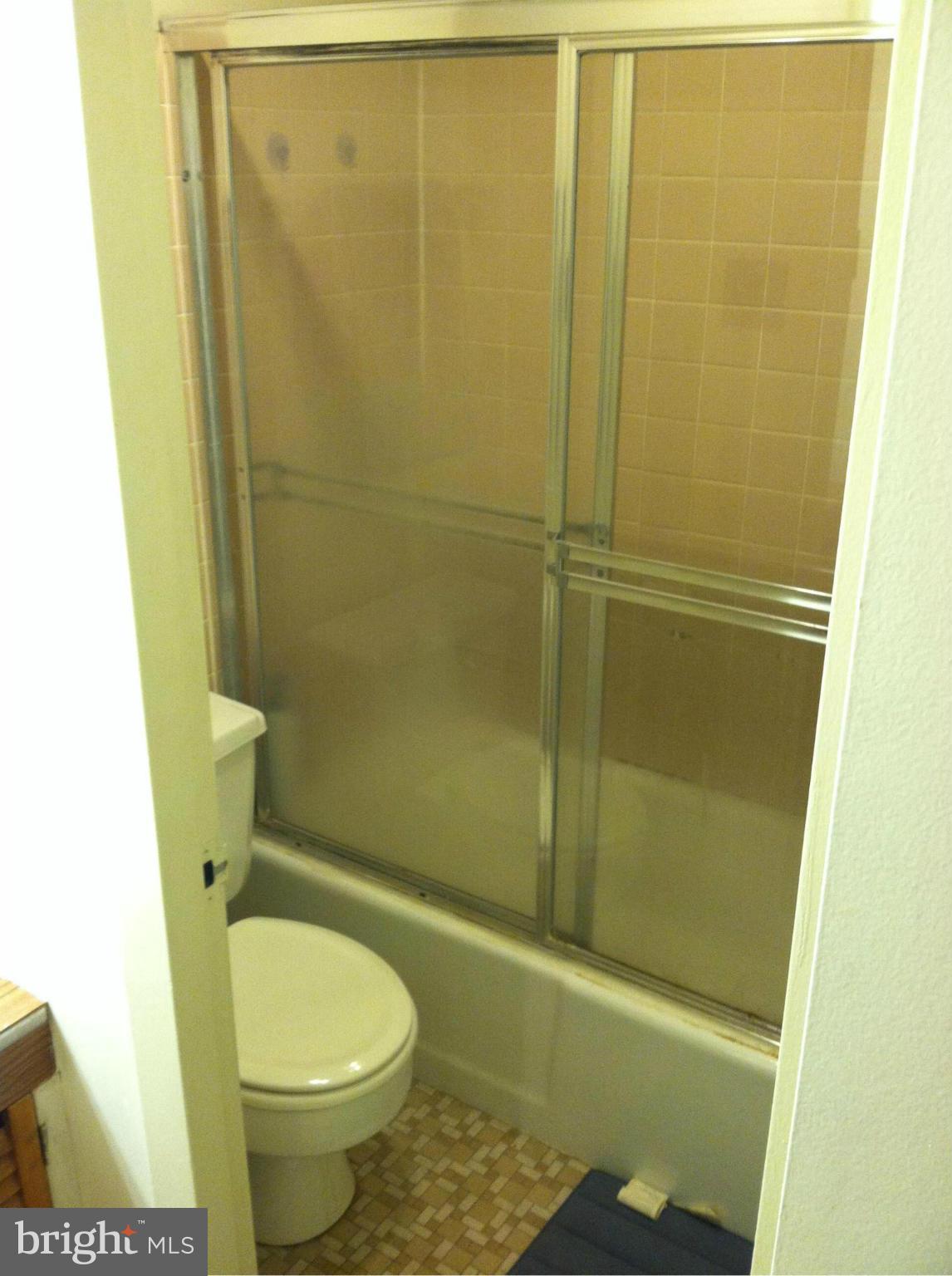 2201 L Street Northwest, Unit 820 Washington, DC 20037 - Photo 6 of 12 a bathroom with a granite countertop toilet and shower