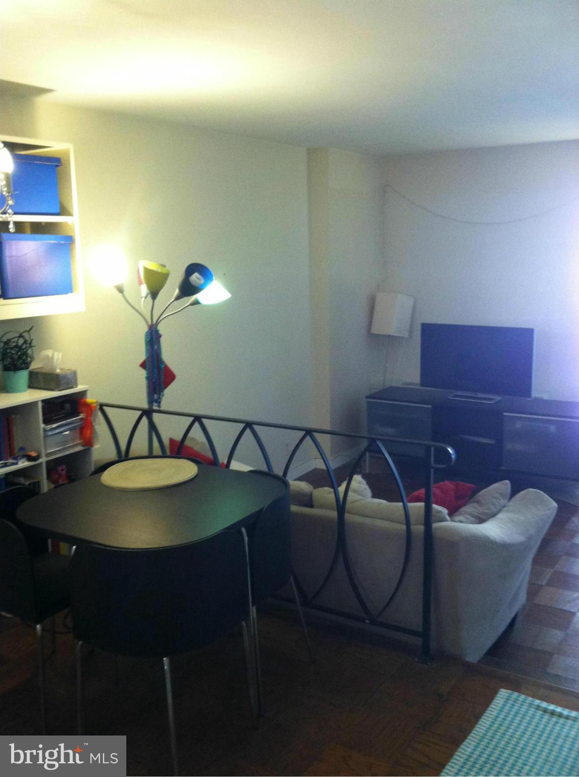 2201 L Street Northwest, Unit 820 Washington, DC 20037 - Photo 7 of 12 a living room with furniture and a lamp