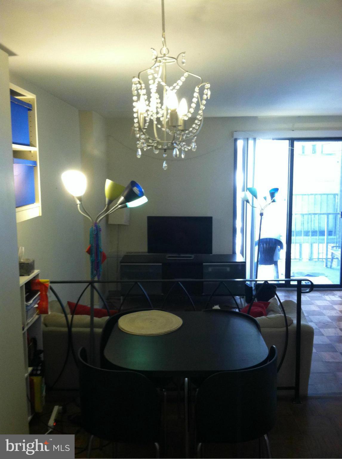 2201 L Street Northwest, Unit 820 Washington, DC 20037 - Photo 8 of 12 a view of a dining room with furniture a chandelier and large windows
