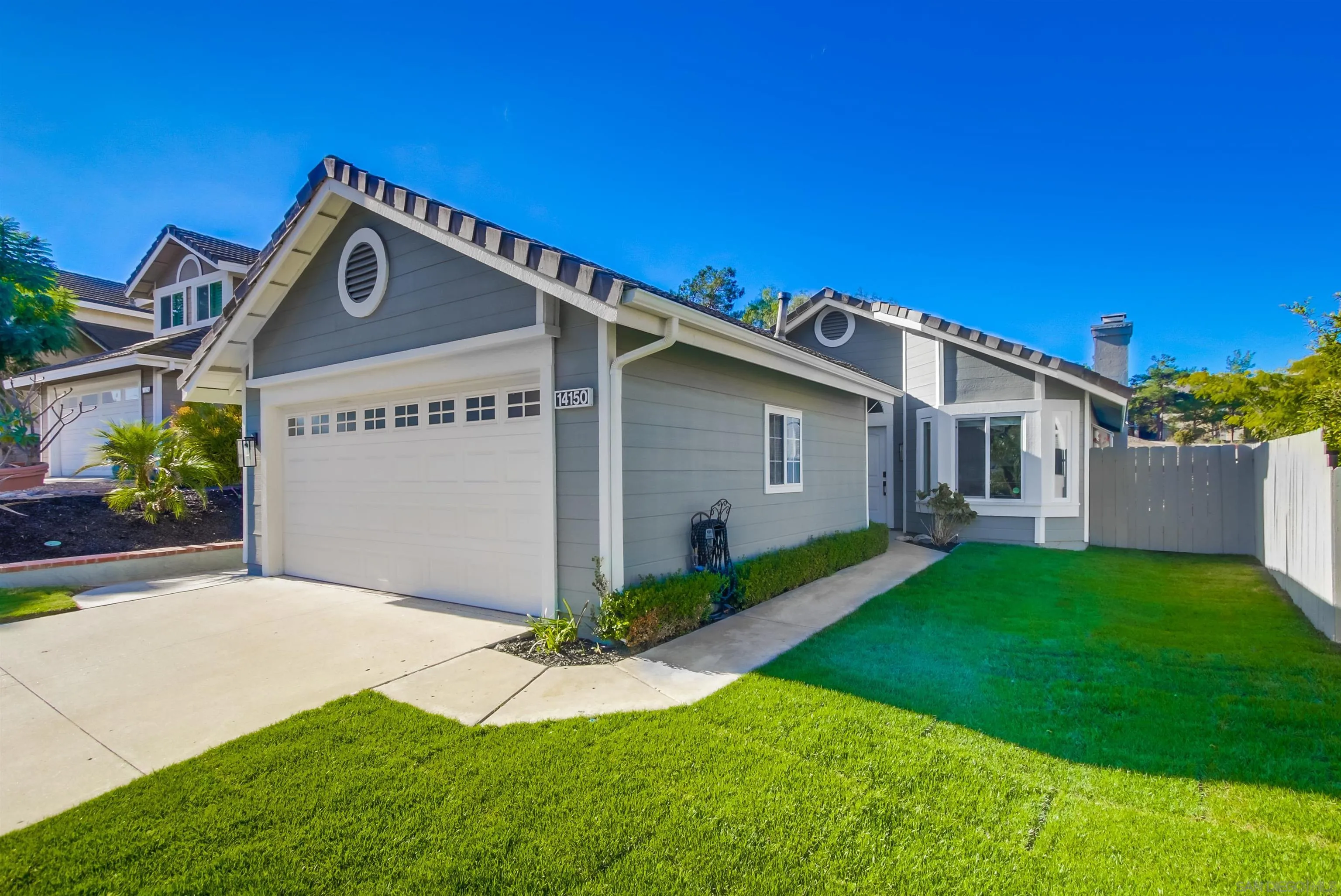 14150 Carmel Ridge Road San Diego, CA 92128 - Photo 2 of 21 a front view of a house with a yard and garage