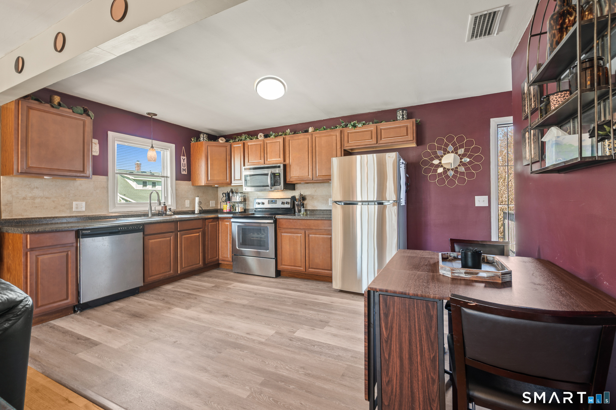 192 Wolcott Hill Road Wethersfield, CT 06109 - Photo 4 of 35 a kitchen with stainless steel appliances granite countertop a refrigerator sink and wooden cabinets