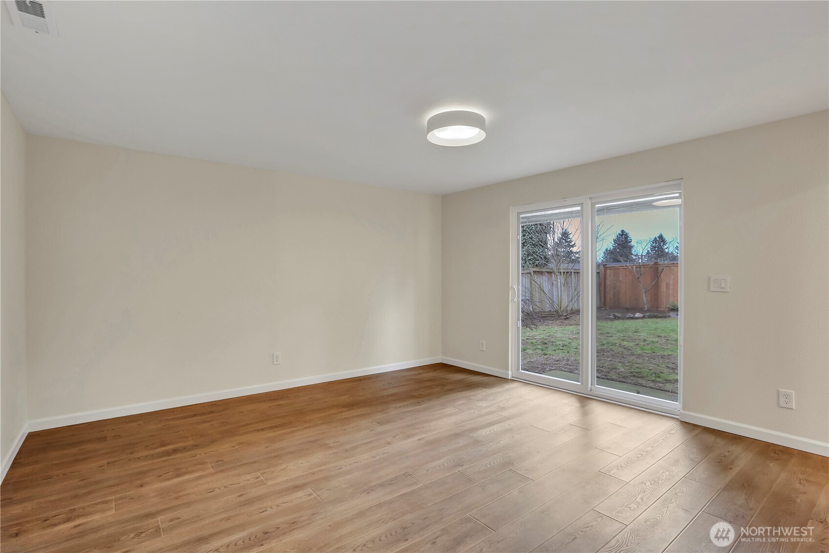 16387 129th Avenue Southeast Renton, WA 98058 - Photo 17 of 30 an empty room with wooden floor and windows