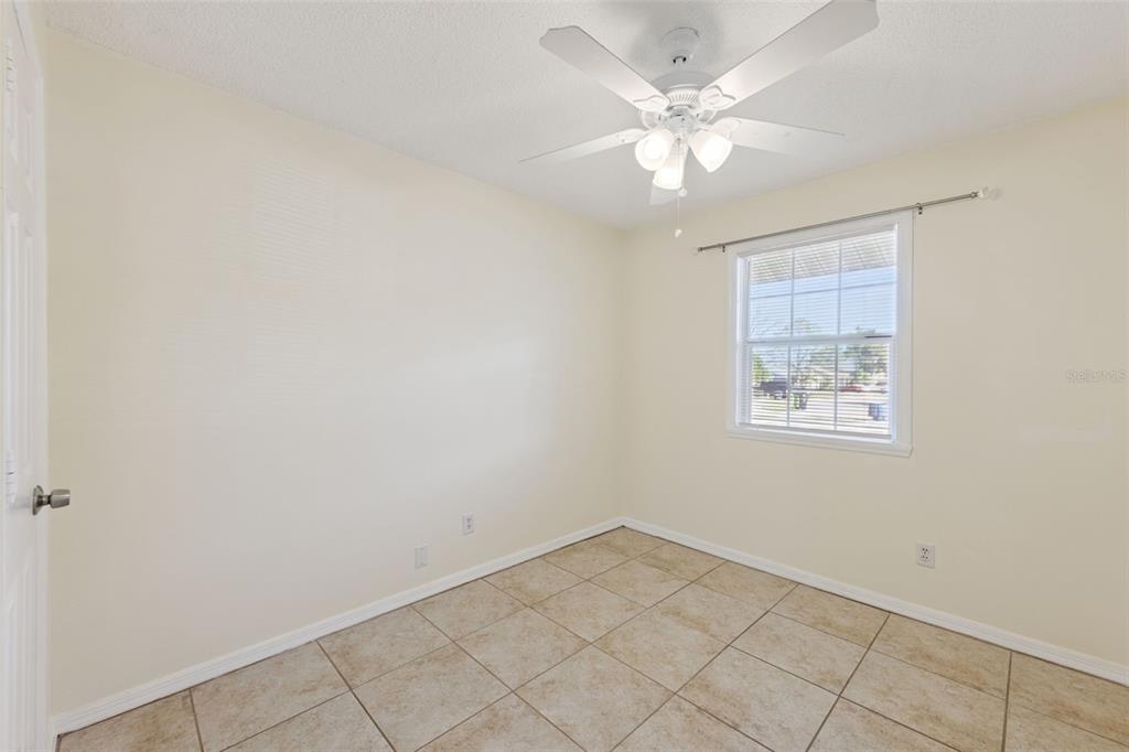 212 Ridge Crest Loop, Unit B Minneola, FL 34715 - Photo 15 of 21 an empty room with a chandelier fan and windows