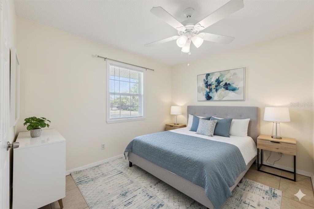 212 Ridge Crest Loop, Unit B Minneola, FL 34715 - Photo 18 of 21 a bedroom with a bed and a chandelier