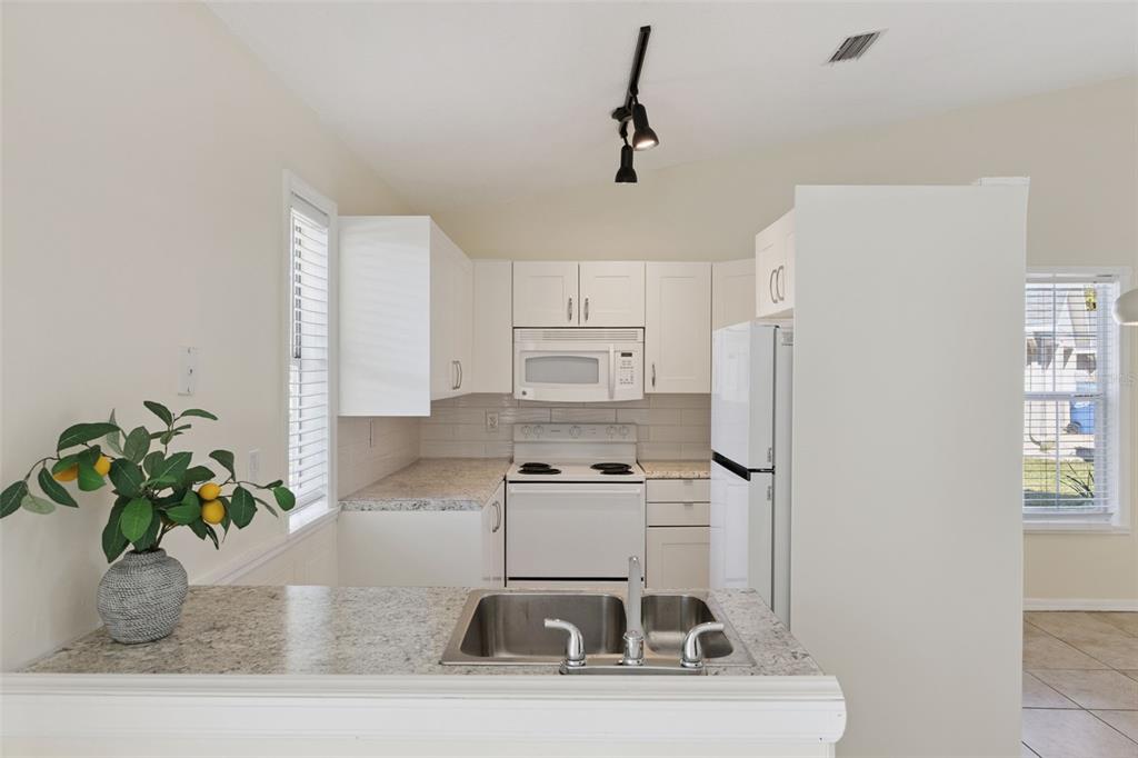 212 Ridge Crest Loop, Unit B Minneola, FL 34715 - Photo 8 of 21 a kitchen with stainless steel appliances granite countertop a sink a stove and a refrigerator