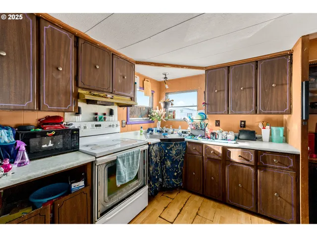 a kitchen with stainless steel appliances granite countertop a stove a sink dishwasher and cabinets with wooden floor