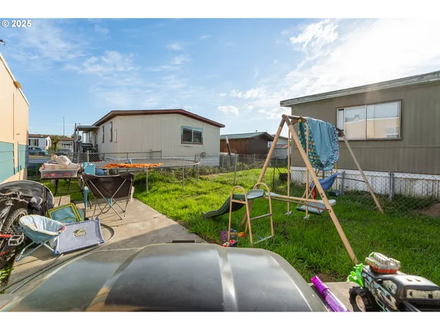 a view of a house with a yard potted plants and a bench