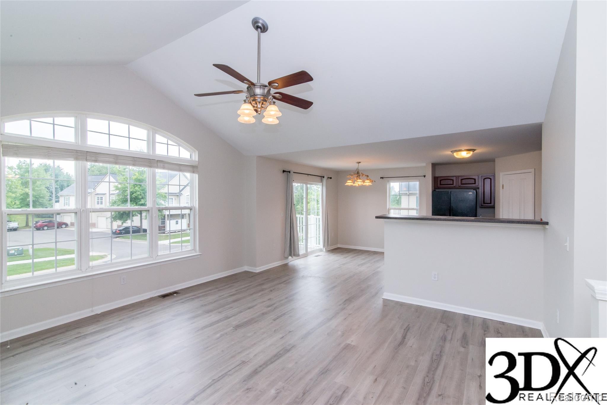 4256 Hampton Ridge Boulevard Howell, MI 48843 - Photo 13 of 25 Vaulted ceiling, ceiling fan, arched transom window, wood-finish flooring, and a breakfast bar
