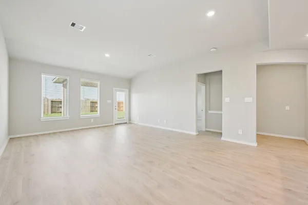 a view of empty room with wooden floor and windows