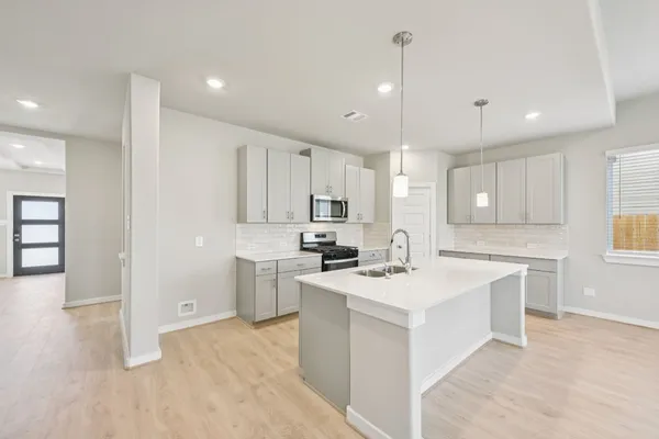 a kitchen with a sink stove and refrigerator
