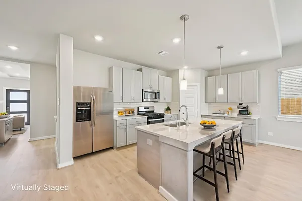 a kitchen with a refrigerator a dining table and chairs
