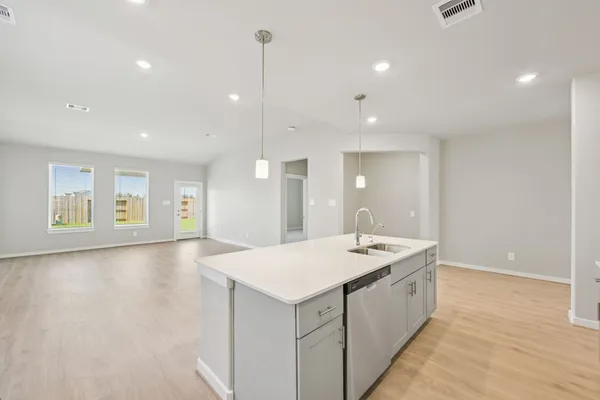 a large white kitchen with a sink and dishwasher