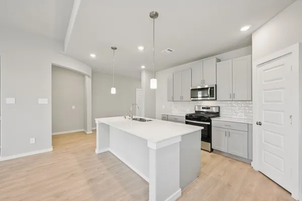 a kitchen with stainless steel appliances kitchen island a sink stove and refrigerator