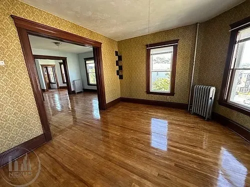 a view of a hallway with wooden floor and windows