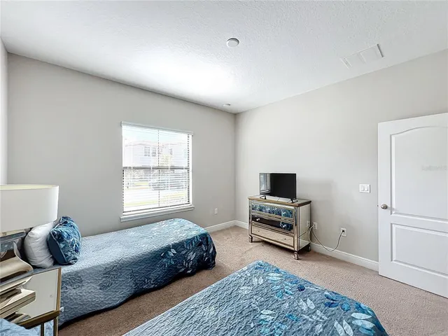 a bedroom with a bed a couch and a window