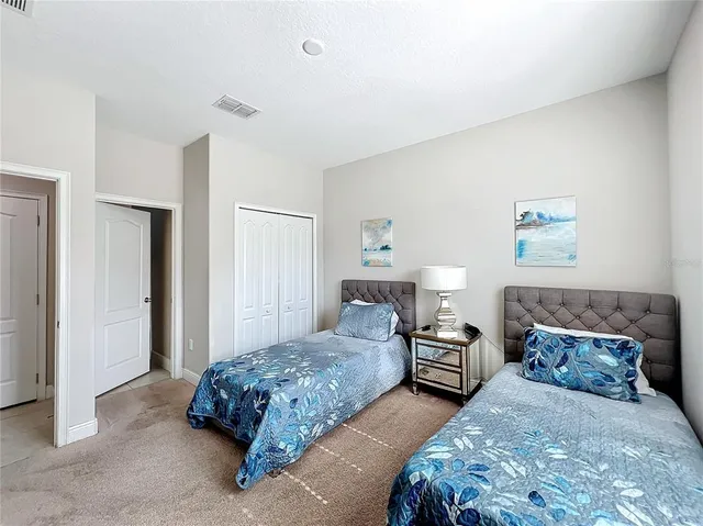 a bedroom with two beds and a lamp