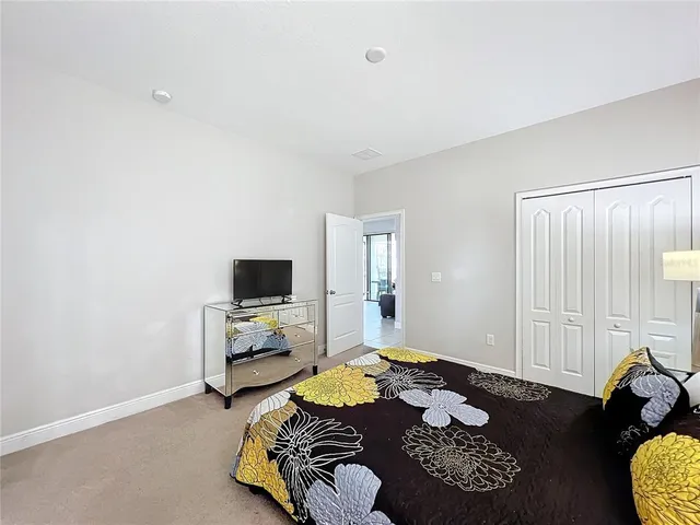 a bedroom with furniture and a flat screen tv