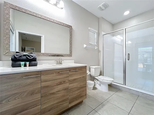 a bathroom with a double vanity sink toilet and shower