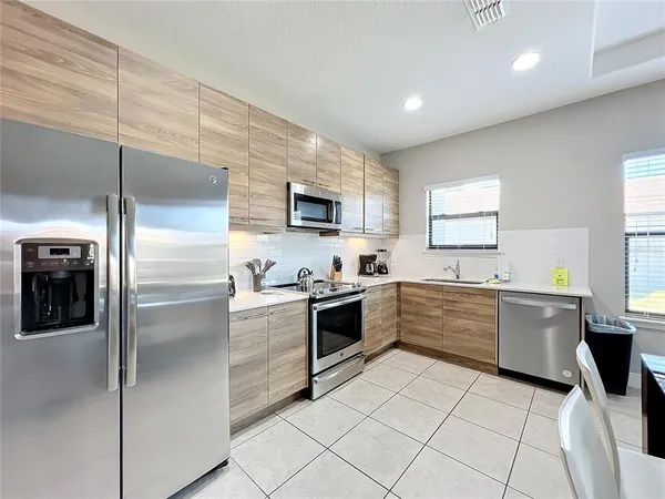a large kitchen with a stove a sink dishwasher a refrigerator and a microwave oven