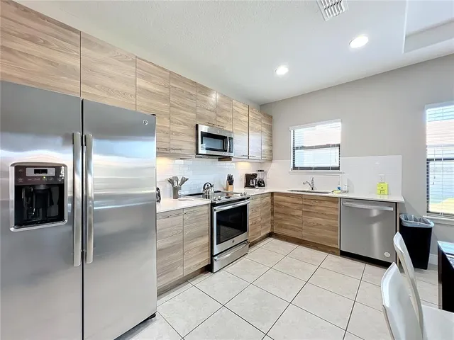 a large kitchen with a stove a sink dishwasher a refrigerator and a microwave oven