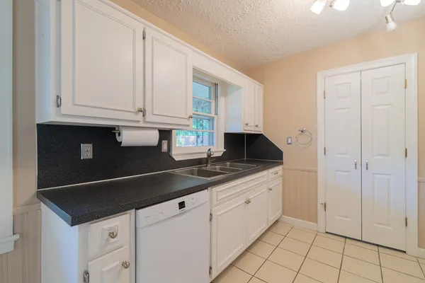 a kitchen with granite countertop white cabinets and sink