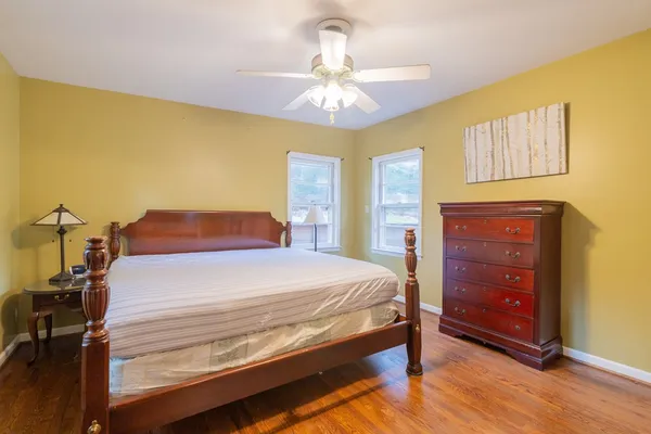 a bedroom with a bed and wooden floor
