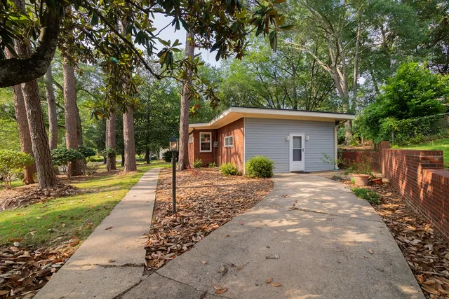 a view of a house with backyard and trees