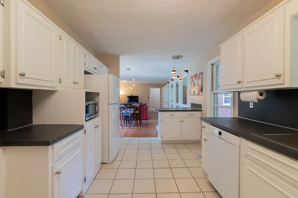 a kitchen with granite countertop a sink and white cabinets