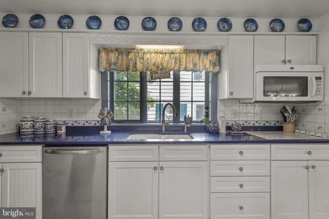 a spacious bedroom with a bed a chandelier and a bookshelf