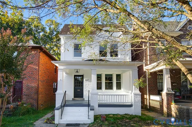 a front view of a house with a tree