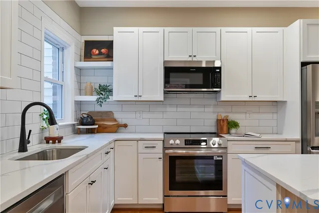 a kitchen with stainless steel appliances a refrigerator stove microwave and cabinets