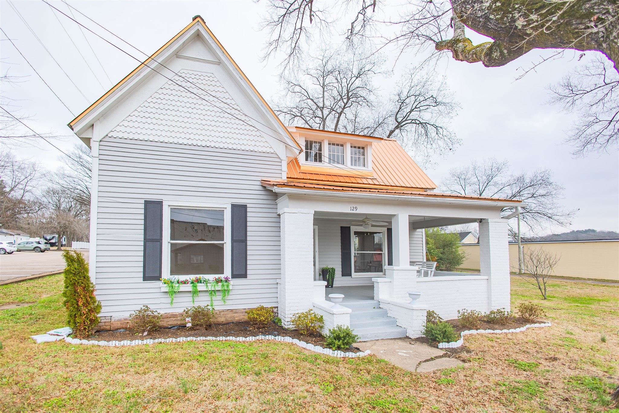 129 Warren Avenue Selmer, TN 38375 - Photo 1 of 28 a front view of a house with a yard and garage