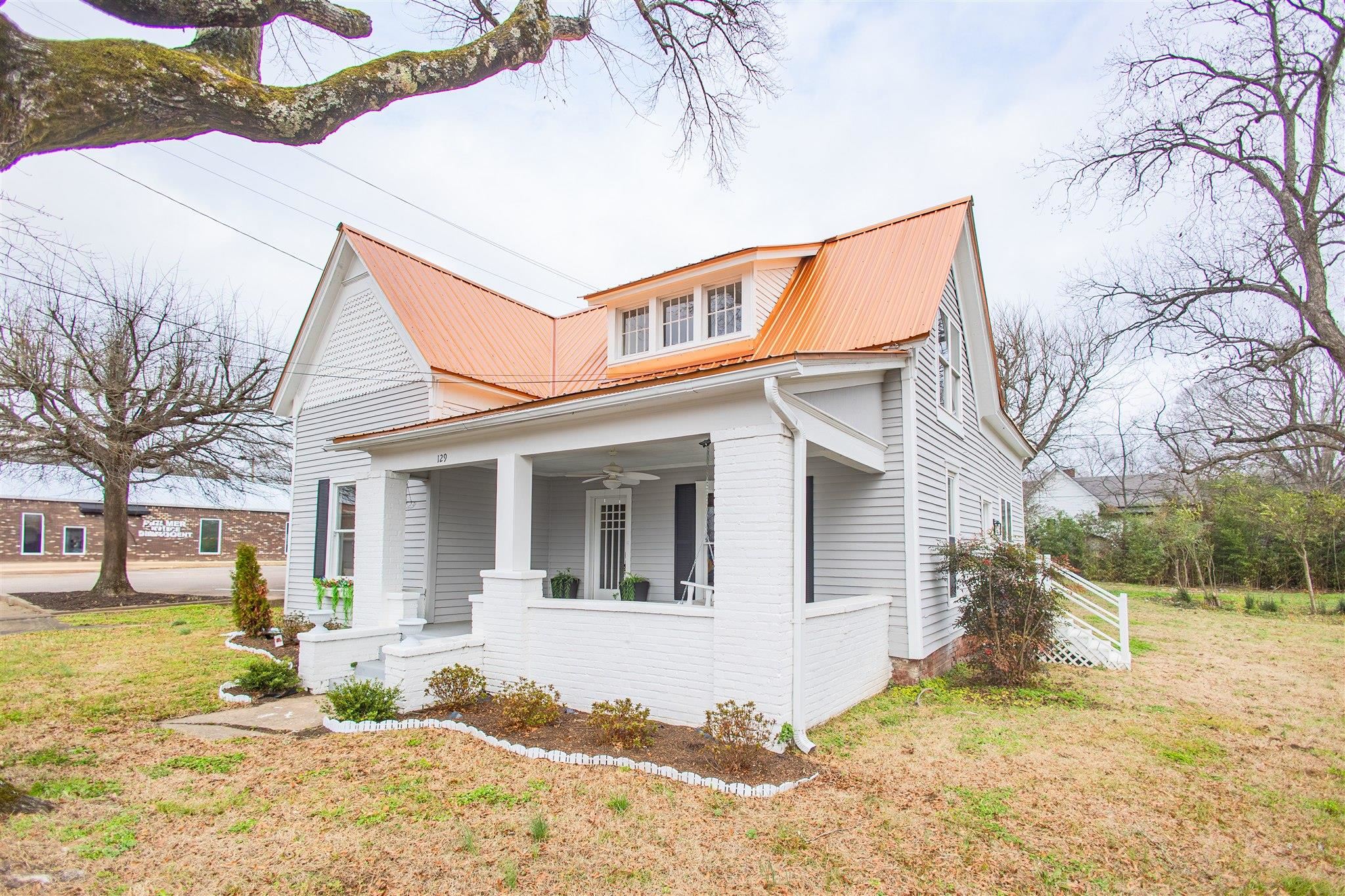 129 Warren Avenue Selmer, TN 38375 - Photo 4 of 28 a view of a white house with a yard covered in snow