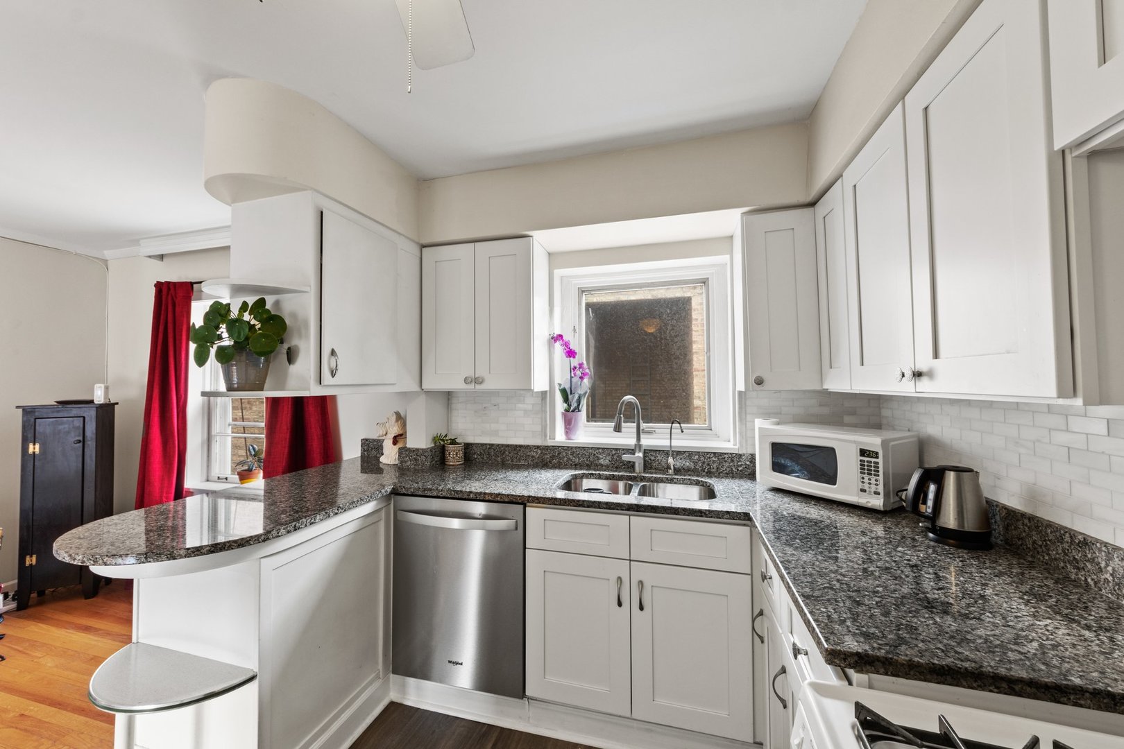 1408 Central Street, Unit 3N Evanston, IL 60201 - Photo 8 of 17 a kitchen with white cabinets a sink dishwasher and a stove with wooden floor