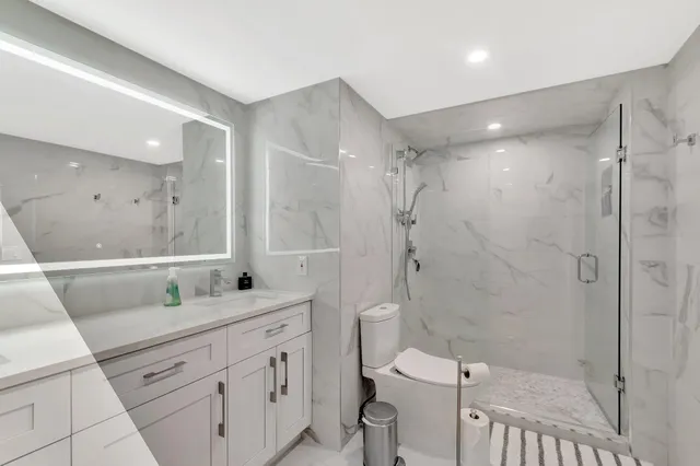 a bathroom with a double vanity sink toilet and shower