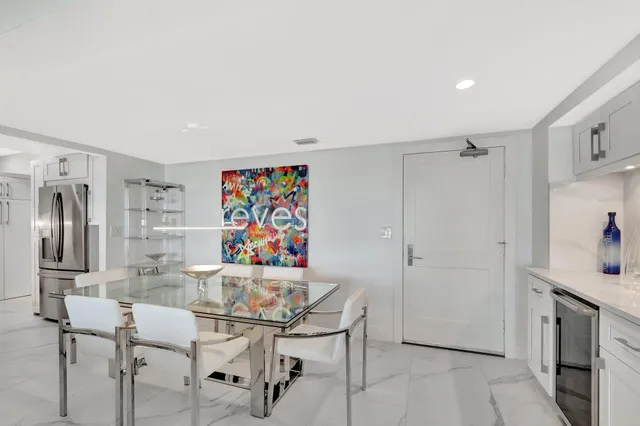 a kitchen with stainless steel appliances kitchen island granite countertop a refrigerator and a sink