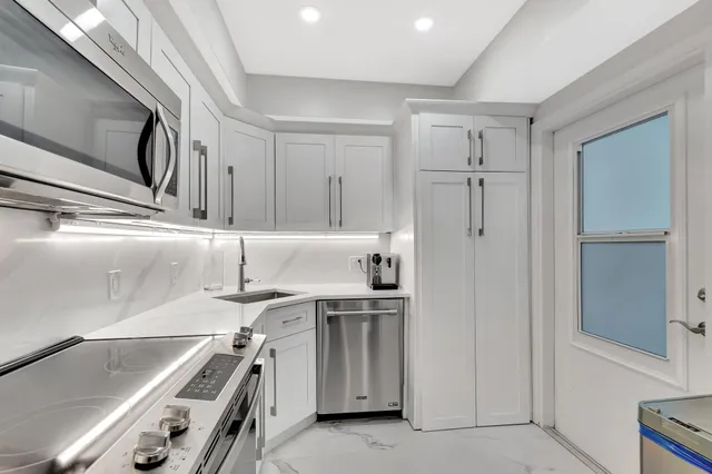 a kitchen with a sink stainless steel appliances and cabinets