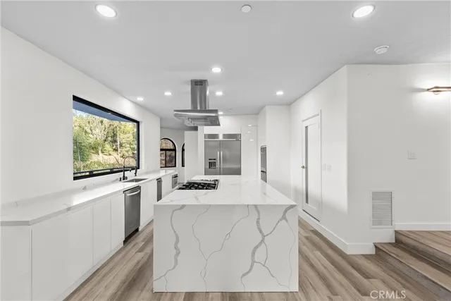 a view of a kitchen with wooden floor and windows