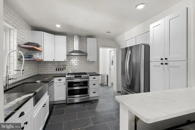 a kitchen with kitchen island a sink stove and refrigerator