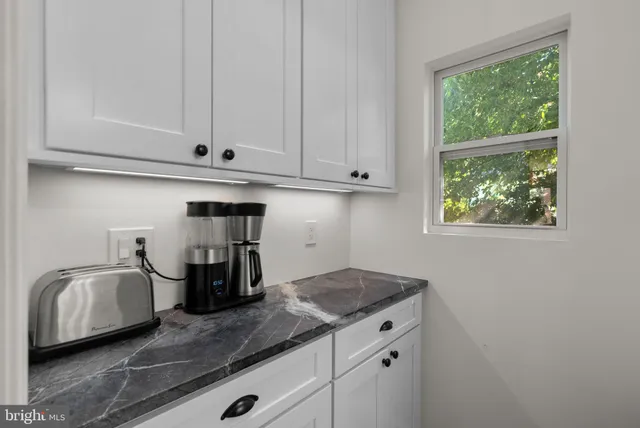 a kitchen with granite countertop a sink and a stove next to a window