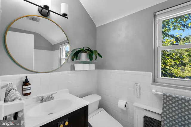 a bathroom with a sink a toilet and a mirror