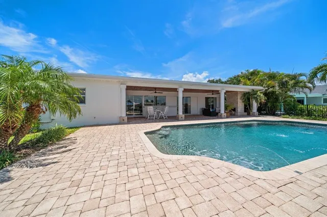 a view of a house with swimming pool and sitting area