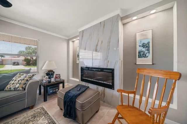 a living room with furniture a fireplace and a large window