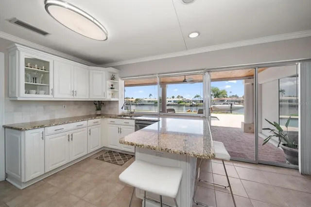a kitchen with granite countertop a stove a sink and a refrigerator