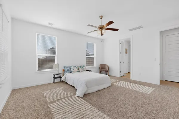 a bedroom with a bed a window and a chandelier
