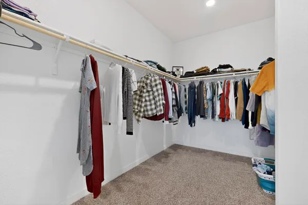 a view of walk in closet with clothes