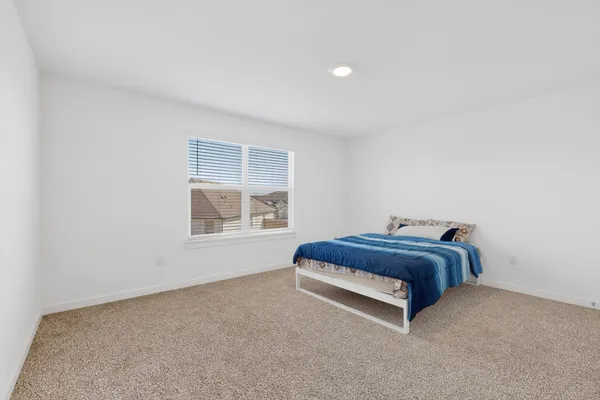 a spacious bedroom with a bed and window