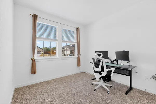 a view of a workspace with furniture and a window